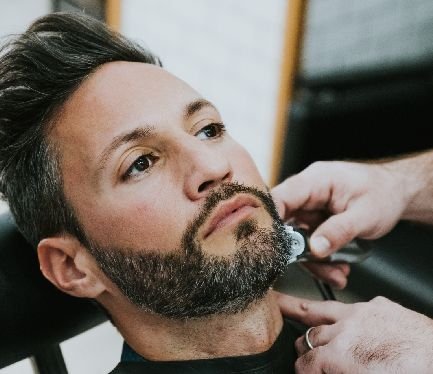 httpselements.envato.combarber cutting beard to man in salon U5TQX9X.jpg