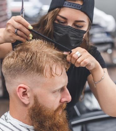 httpselements.envato.comwoman barber cutting hair to a bearded man in face QAVUWJQ.jpg